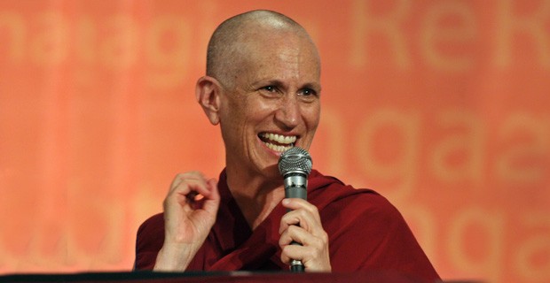 Venerable holding a microphone and smiling.