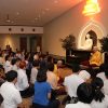 Venerable teaching in front of a large crowd at Nalanda Buddhist Centre.