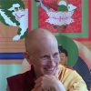 Ven. Chodron smiling during a teaching, with her chin on her hand.