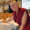 Venerable Chonyi smiling while sorthing through bins of mail.