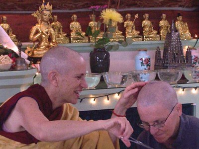 Venerable Chodron cutting the hair of Venerable Semkye (then Nancy).