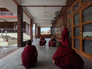 Suore tibetane inginocchiate che rotolano marmi.