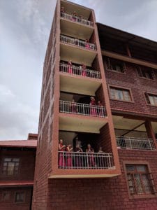 Tibetan nuns on balcony of building, performing experiments.