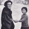 Elderly man and young child holding hands and smiling.