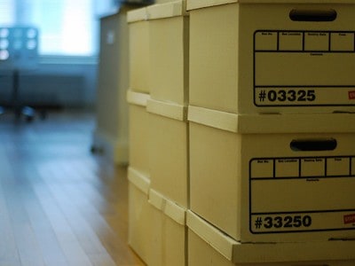 Boxes stacked in a room with a wooden floor.