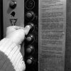 Person's finger pushing a button in an elevator.