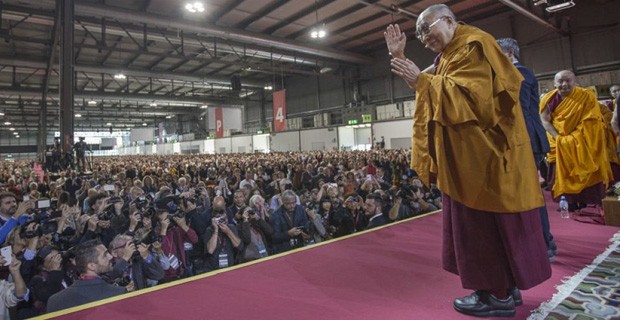 His Holiness the Dalai Lama waving to a large crowd at a teaching.