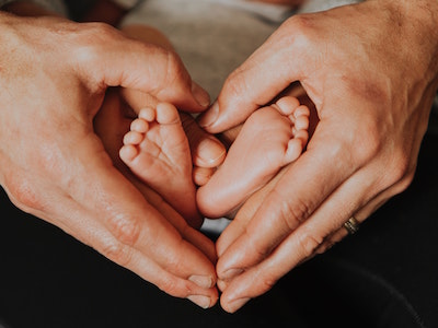 Adults hands holding a baby's feet.