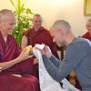 Stephen kneeling in front of Venerable Chodron and offeirng a khata.