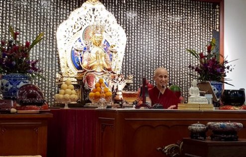 Ven. Chodron sits and teaches in front of a Maitreya statue at Vimalakirti Buddhist Centre Singapore.