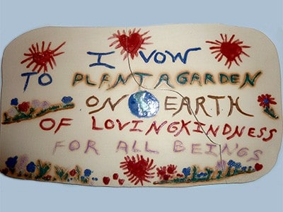 Placa que diz: "Prometo plantar um jardim na terra de bondade amorosa para todos os seres".