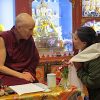Venerable smiling and speaking to a student.