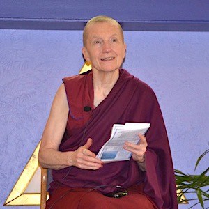 Ven. Sangye Khadro smiling and holding a text while teaching at Gardenia Center.
