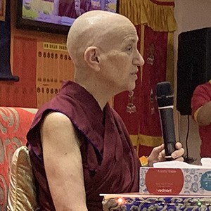 Venerable holding a microphone and teaching.