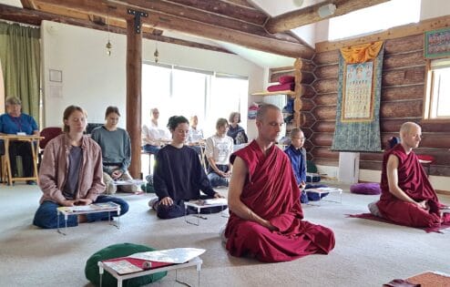 Grupa medytujących mnichów i świeckich.