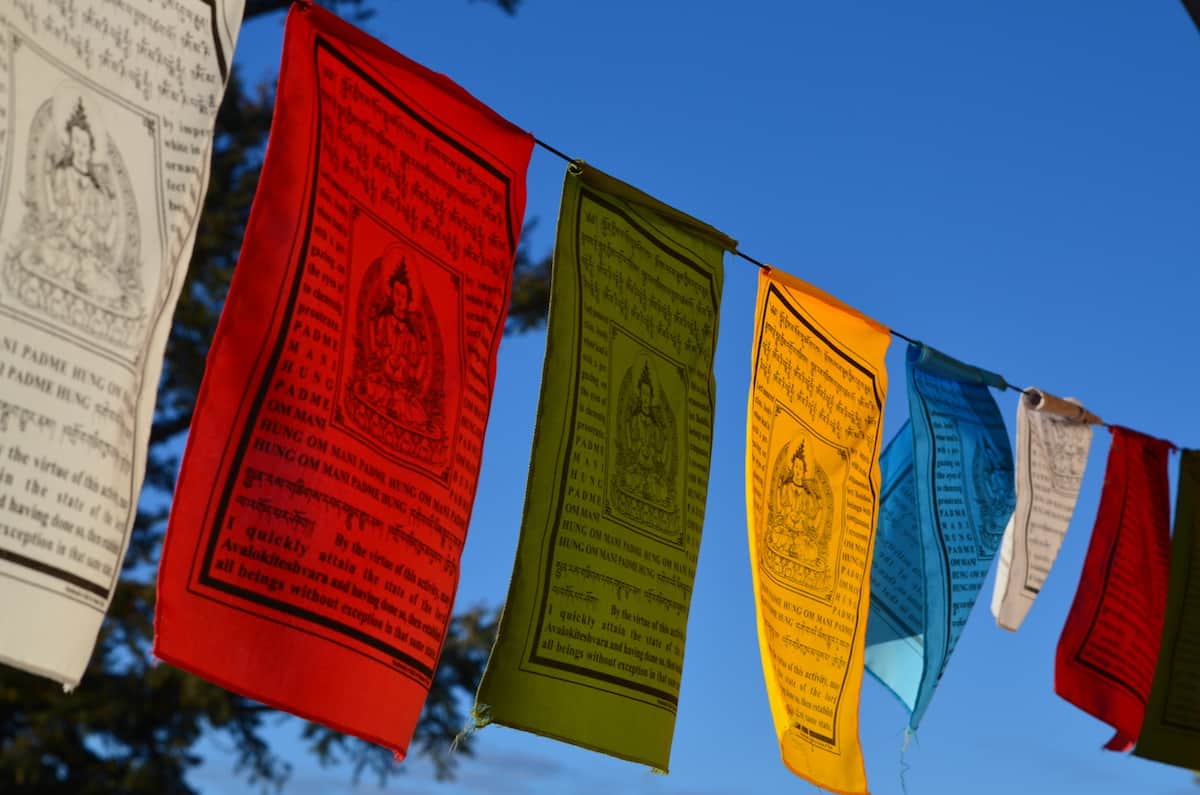 Colorful prayer flags against a clear blue sky.