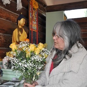 Cheri stojąca przed ołtarzem, oferująca żółte róże.