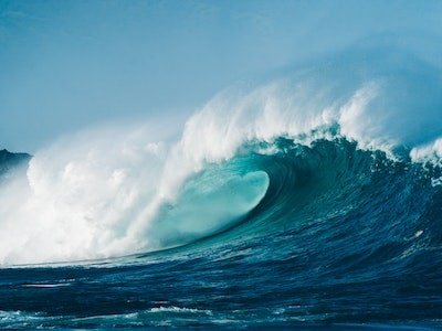 موجة رغوية تتدحرج على سطح البحر اللازوردي.