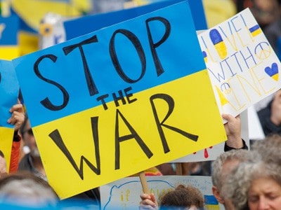 Blue and yellow sign that says stop the war.
