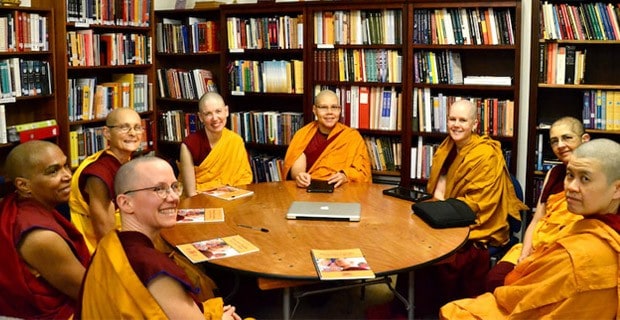 مجموعة من shiksamanas في مكتبة الدير يقرأون مبادئهم على المائدة المستديرة.