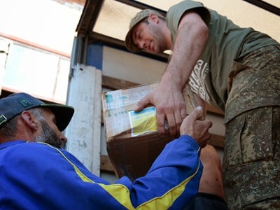 Aid worker passing out supplies to a Ukrainian man during time of war.