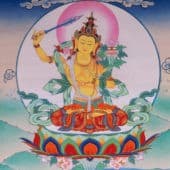 Bodhisattwa Mandziuśriego jest koloru pomarańczowego, w prawej ręce trzyma miecz, aw lewej lotos z napisem.