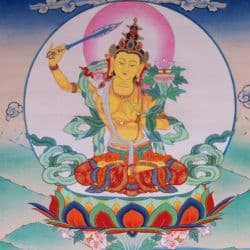 Manjushri bodhisattva is orange in color and holds a sword in his right hand and a lotus with a text on it in his left hand.