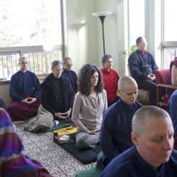 A room full of people sitting in meditation.