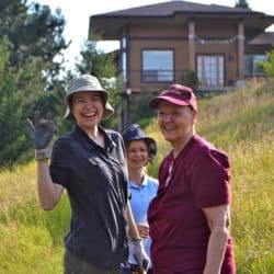 Exploring Monastic Life participants wave and smile from the lower meadow in front of Gotami House.