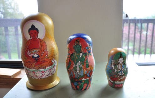 Three Russian dolls with Amitabha, Green Tara, and Vajrasattva painted on them.
