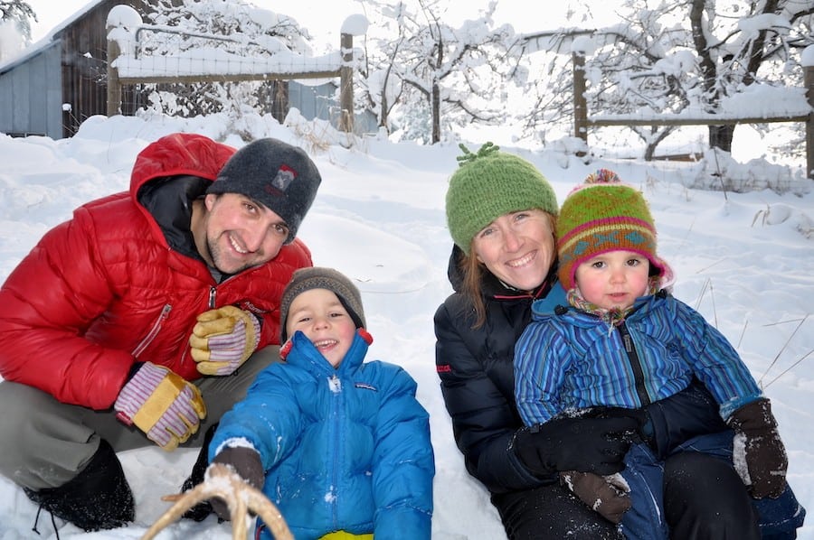 Parents and their two young children have fun in the snow at Sravasti Abbey.