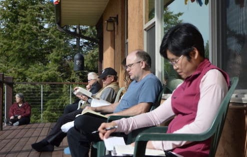 Guest read Dharma books on the Chenrezig Hall deck.