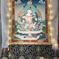 Vajrasattva painting framed by brocade, lights, and a white scarf.