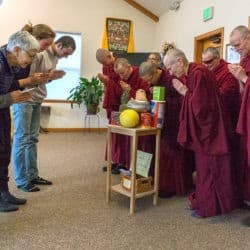 Sravasti Abbey monastics and lay friends bow to each other during a food offering ceremony.