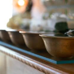 A row of water bowls on an altar.