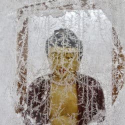 Buddha statue behind a glass panel covered in frost.