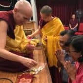 Venerable Chodron gives out mani pills to a couple at Buddhist Gem Fellowship.