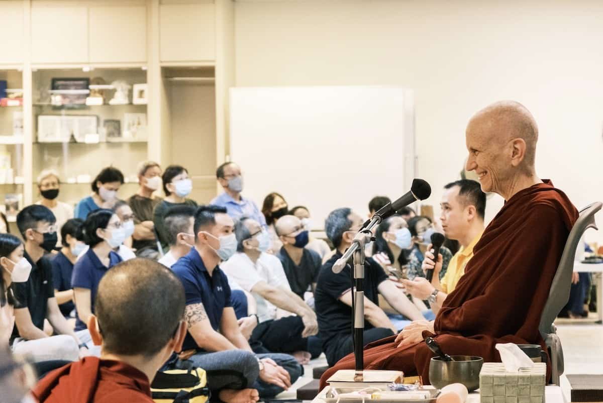 Venerable Chodron smiling while teaching to a large crowd.