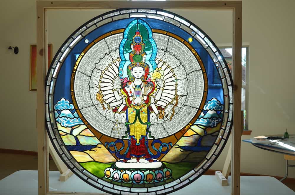 Stained glass image of One thousand-armed Chenrezig.