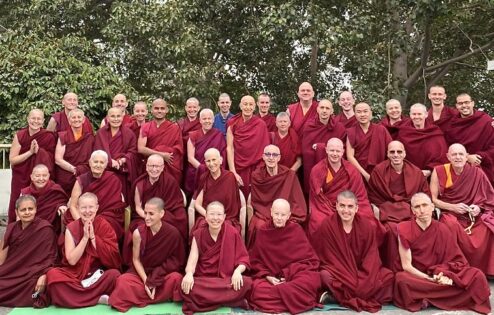 A large group of Tibetan monastics gathered together.