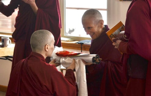 Buddhistische Nonne bringt ihrem Lehrer eine Opfergabe dar.